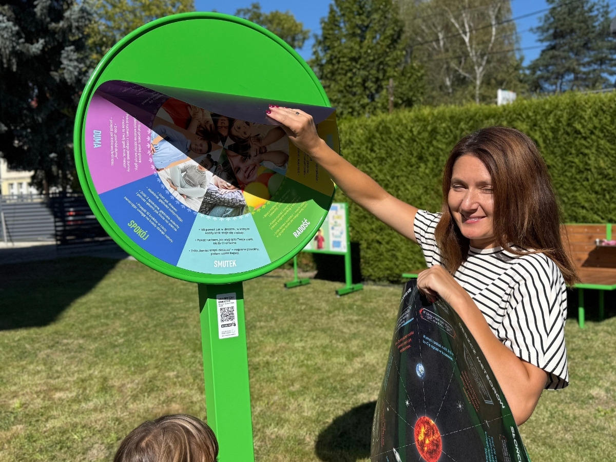 Dłonie zdejmują magnetyczną tarczę z&nbsp;koła edukacyjnego, pod spodem widać metalową podstawę