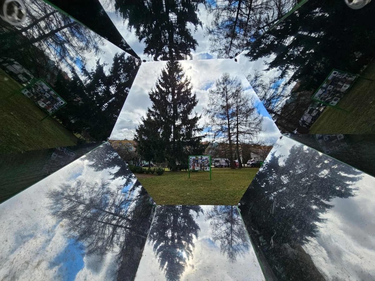 Inside the kaleidoscope: polished mirrors meeting at an angle, with multiple reflections of a child's face