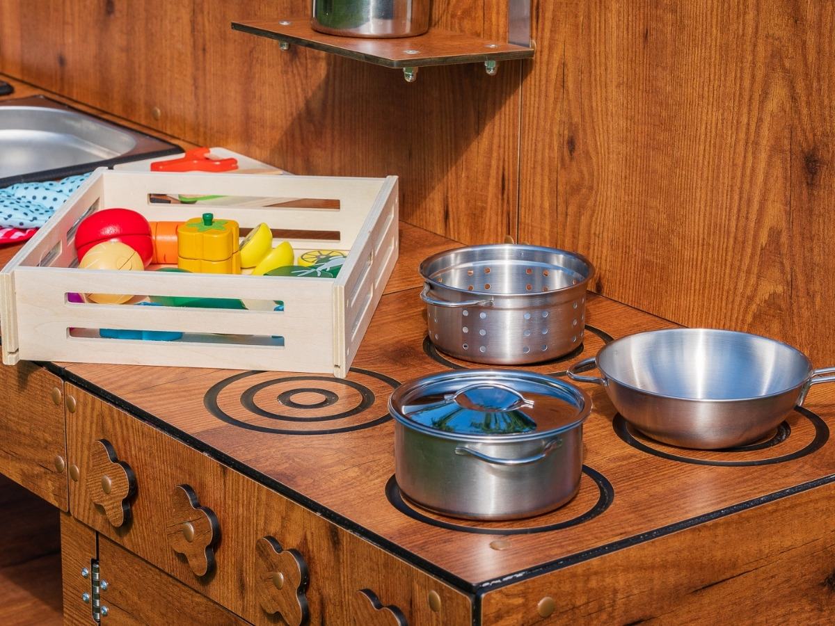 Circles milled into the worktop imitating cooker burners, with metal pots and bowls on them