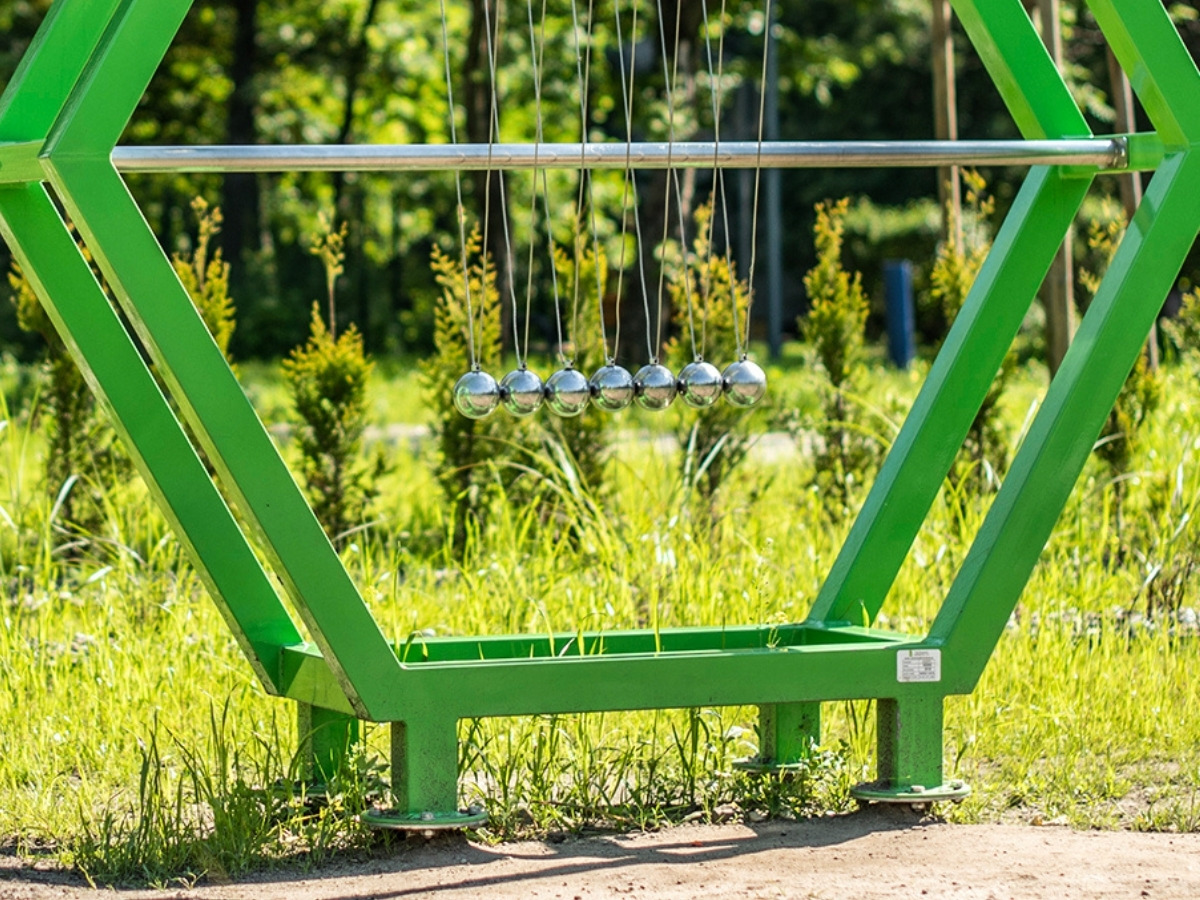 The base of a Newton's cradle post bolted to an anchor set in the ground