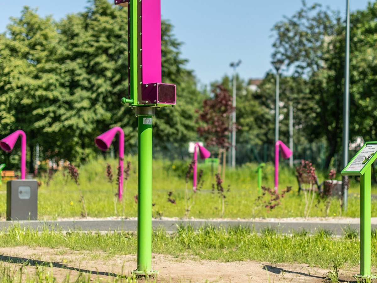 Stalowa kolumna peryskopu zakotwiona w&nbsp;nawierzchni placu, obok ogrodzenie