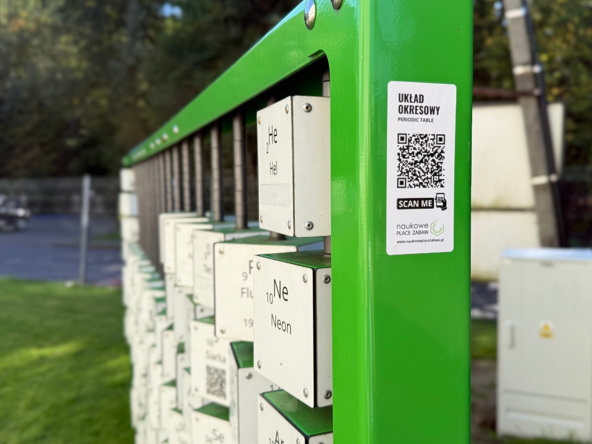 Zielona rama układu okresowego z&nbsp;kostkami helu i&nbsp;neonu, na kostce i&nbsp;na naklejce urządzenia kody QR do platformy