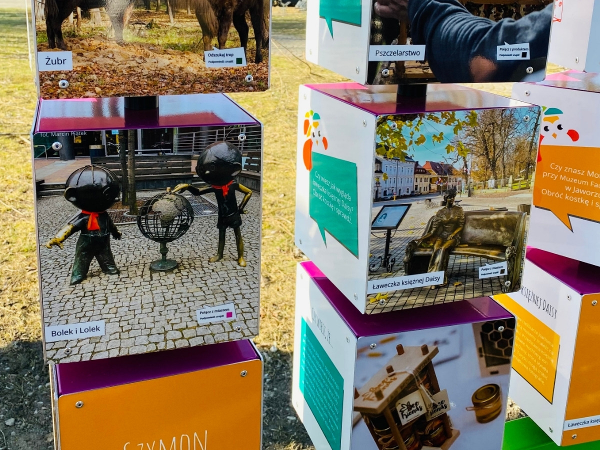 Cztery sąsiednie kostki obrócone różnymi ściankami, na każdej inny nadruk: obrazek, zadanie i&nbsp;odpowiedź