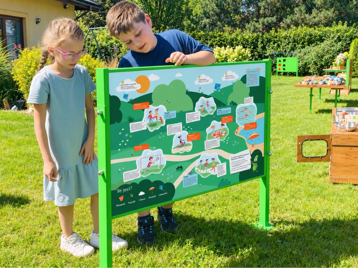 Dwustronna tablica edukacyjna w&nbsp;jednej ramie, dzieci stoją po obu stronach planszy