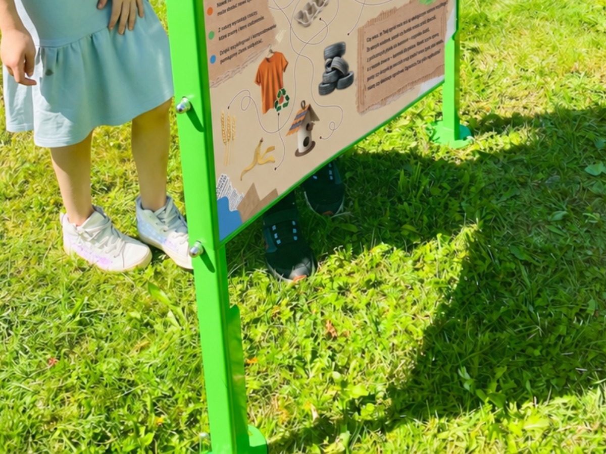 Podstawa tablicy edukacyjnej osadzona kotwami w&nbsp;gruncie, widoczne połączenie śrubowe słupka