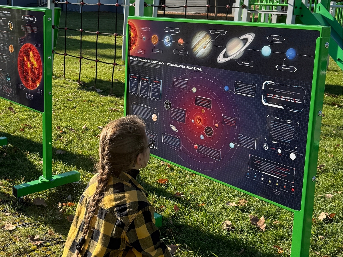 Dłoń dziecka przykłada magnetyczny element do stalowej planszy tablicy edukacyjnej