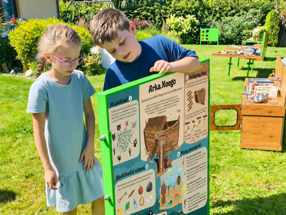 Dwustronna tablica edukacyjna w&nbsp;jednej ramie, dzieci stoją po obu stronach planszy
