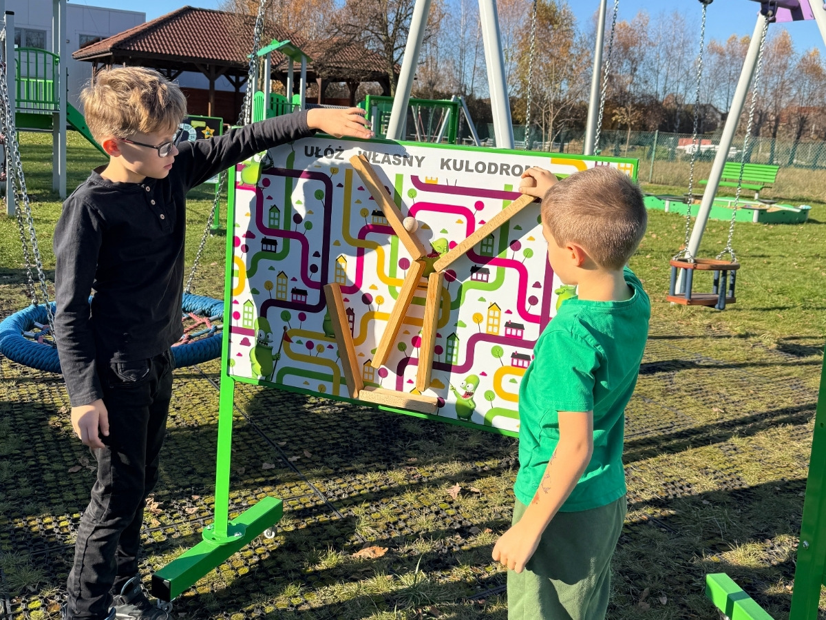 Drewniana kulka zjeżdża po torze kulodromu na planszy tablicy edukacyjnej