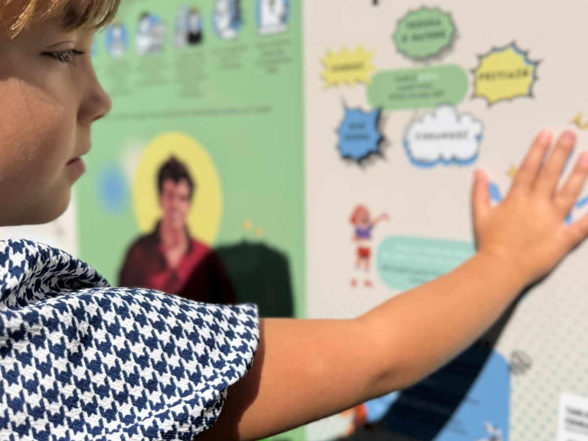 Dłoń dziecka przykłada magnetyczny element do stalowej planszy tablicy edukacyjnej