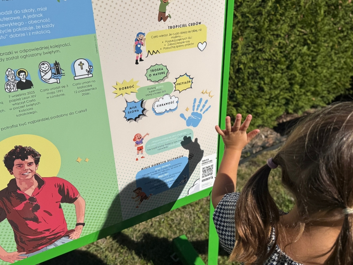Dwustronna tablica edukacyjna w&nbsp;jednej ramie, dzieci stoją po obu stronach planszy