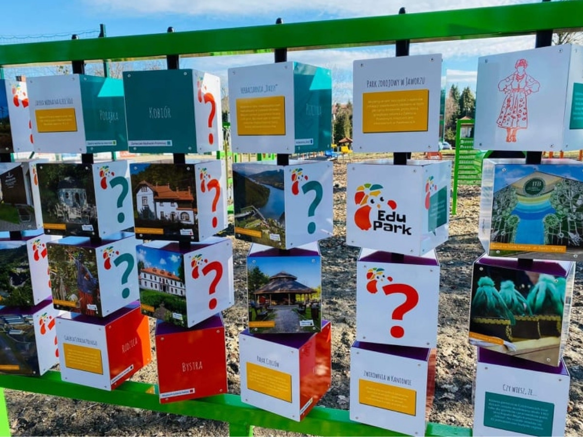 Memory na zielonej ramie z kostkami wykonanymi na zamówienie: logo Edu Park i zdjęcia lokalnych miejsc