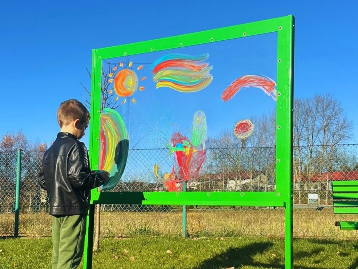 A boy drawing on a transparent board